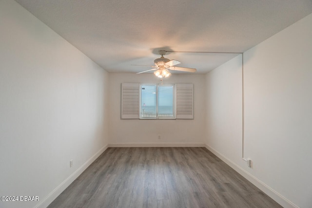 spare room with wood-type flooring, ceiling fan, and a textured ceiling