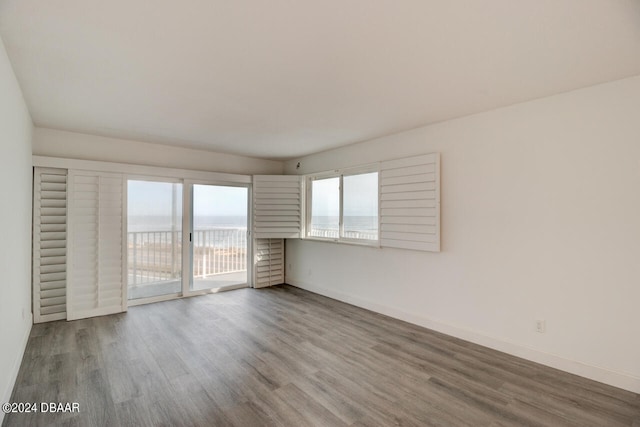 unfurnished room with a water view and wood-type flooring