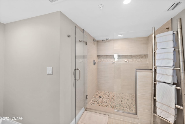 bathroom with a shower with door and tile patterned floors