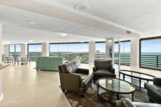 living room featuring a water view, floor to ceiling windows, a textured ceiling, light hardwood / wood-style flooring, and crown molding