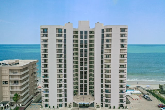 view of property with a water view and a beach view