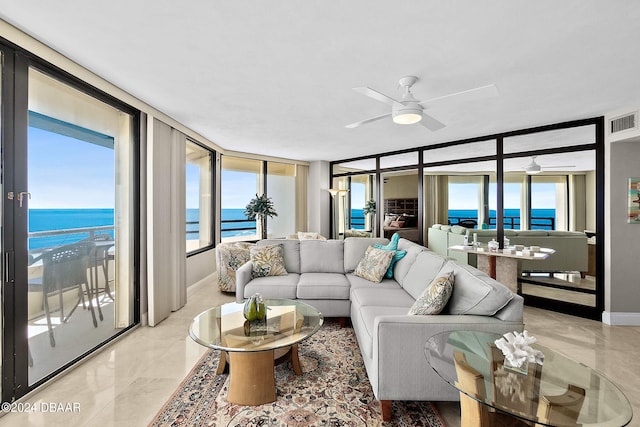 living room featuring a wall of windows, a beach view, a water view, and ceiling fan