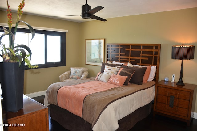 bedroom with dark hardwood / wood-style flooring and ceiling fan