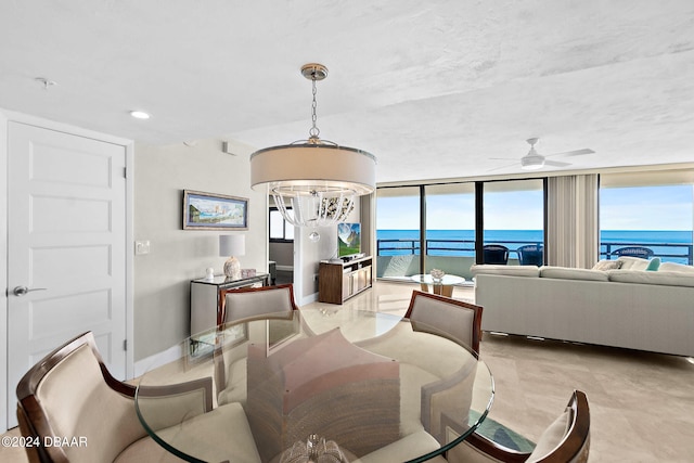 dining room featuring a wall of windows and ceiling fan with notable chandelier