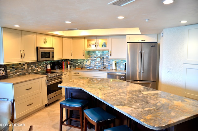 kitchen with white cabinetry, sink, appliances with stainless steel finishes, and a center island