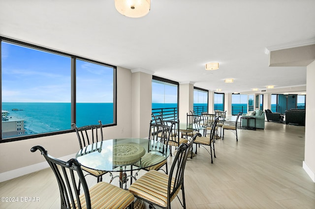 dining room with expansive windows and a water view