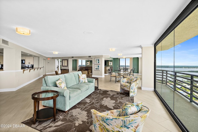 living room featuring a water view and a wall of windows