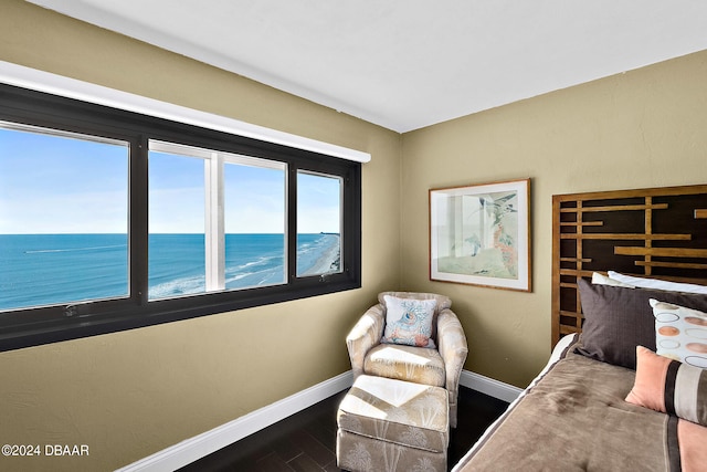 bedroom featuring a water view and dark hardwood / wood-style flooring