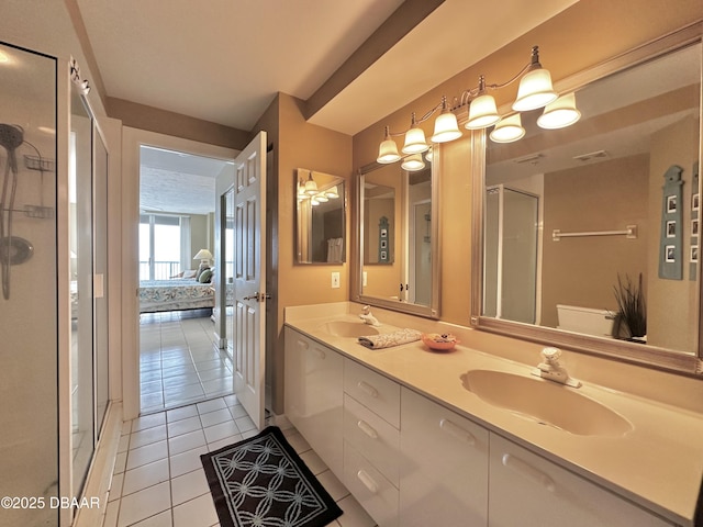 ensuite bathroom featuring tile patterned floors, a stall shower, and double vanity