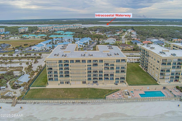 drone / aerial view of a pool area and apartment complex / building