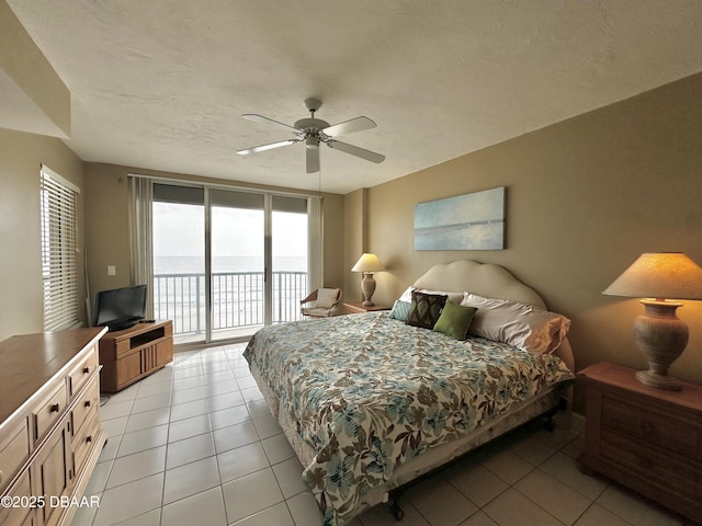 bedroom featuring access to exterior, light tile patterned floors, and multiple windows