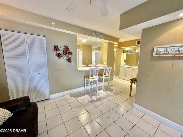 dining space featuring a ceiling fan, light tile patterned flooring, and baseboards