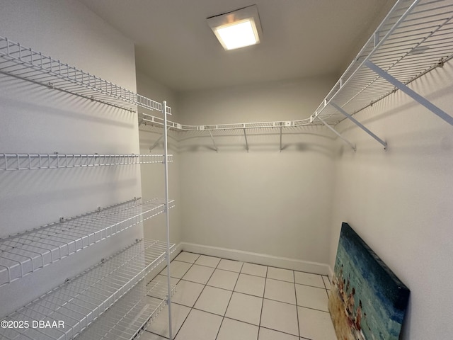 walk in closet with light tile patterned floors