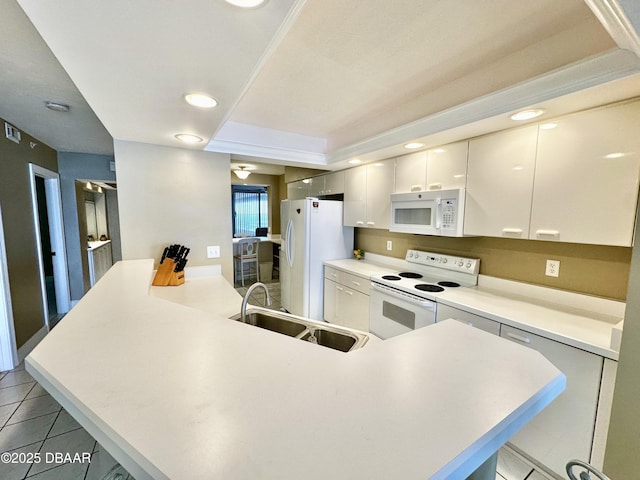 kitchen with white appliances, a sink, a peninsula, white cabinetry, and light tile patterned floors