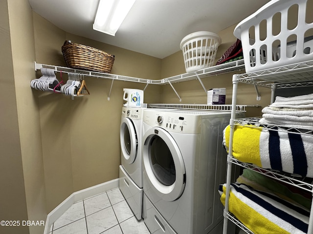 laundry area with washer and clothes dryer, baseboards, and light marble finish floors