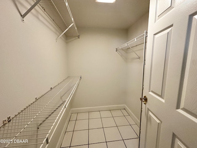 spacious closet with light tile patterned floors