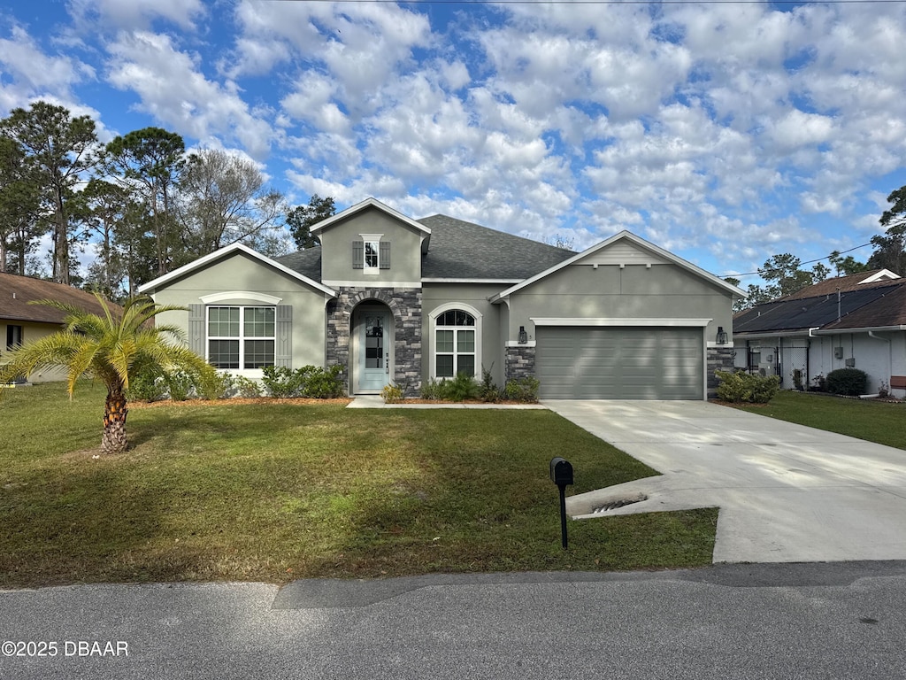 ranch-style house featuring a garage and a front yard