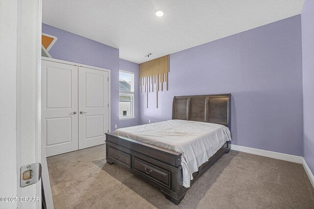 carpeted bedroom with baseboards and a closet