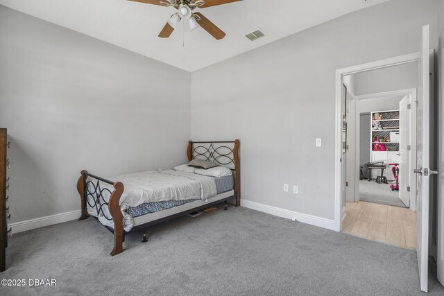 carpeted bedroom featuring a ceiling fan, visible vents, and baseboards