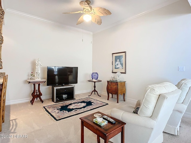 carpeted living area featuring baseboards, ornamental molding, and a ceiling fan