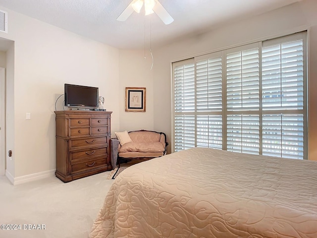 bedroom featuring ceiling fan, visible vents, baseboards, and light colored carpet