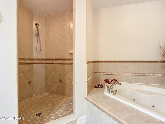 bathroom with a tub with jets and a tile shower