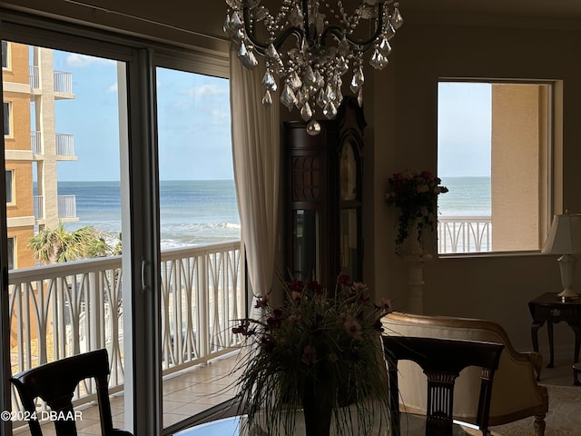 tiled dining area featuring a water view and an inviting chandelier