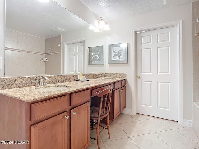 bathroom featuring tiled shower / bath combo, vanity, a textured ceiling, and tile patterned floors