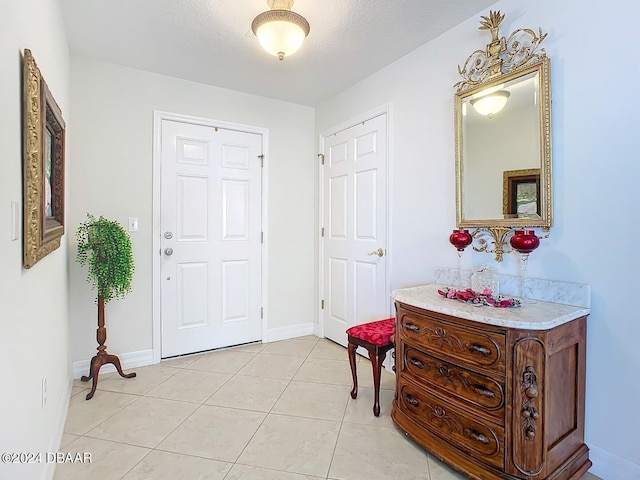 foyer featuring light tile patterned floors and baseboards