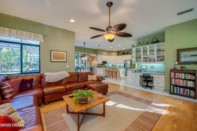 living room with ceiling fan and light hardwood / wood-style flooring