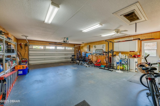 garage with a workshop area and wood walls