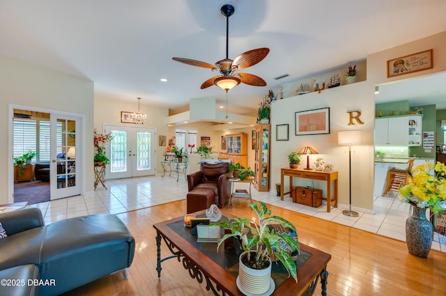 living room with light hardwood / wood-style floors, french doors, and ceiling fan