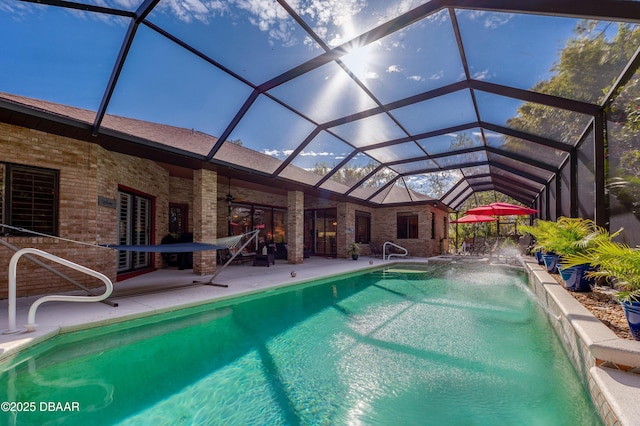 view of swimming pool featuring a patio, pool water feature, ceiling fan, and glass enclosure