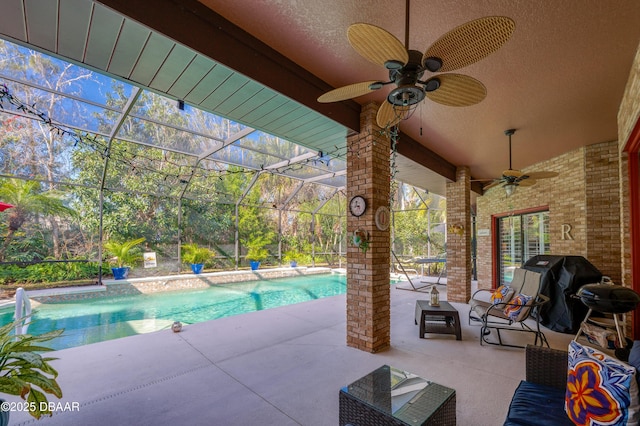 view of swimming pool featuring a lanai, a grill, ceiling fan, and a patio area