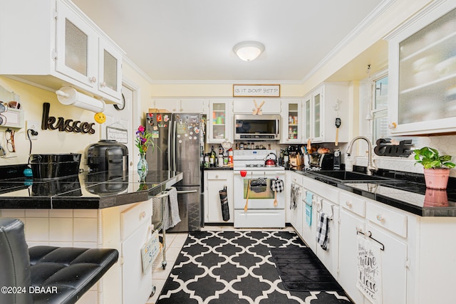 kitchen with stainless steel appliances, white cabinets, sink, light tile patterned flooring, and backsplash