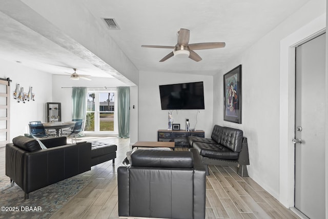 living room featuring a barn door and ceiling fan