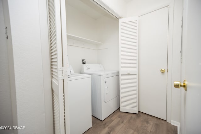 washroom with hardwood / wood-style floors and washing machine and dryer