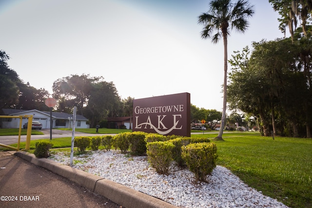 community sign featuring a lawn and a garage