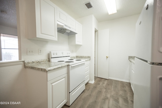 kitchen featuring white appliances, a textured ceiling, light hardwood / wood-style floors, and white cabinets