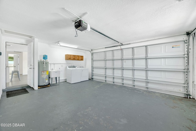 garage with electric water heater, washing machine and dryer, a garage door opener, and a sink