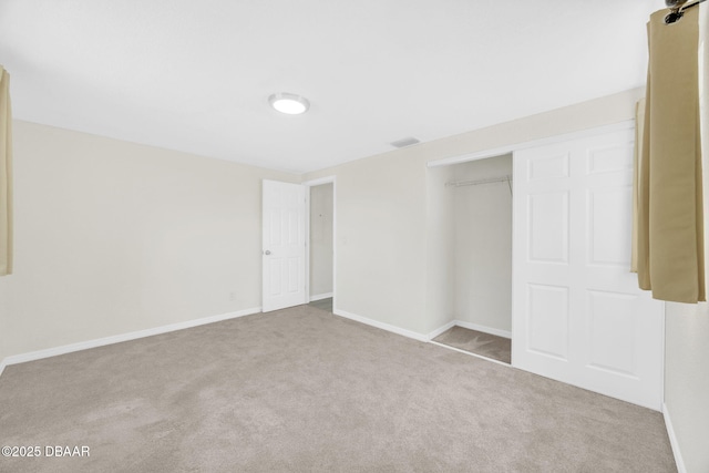 unfurnished bedroom with carpet flooring, baseboards, and a closet