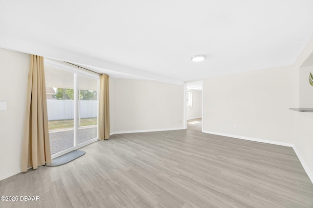 unfurnished living room with wood finished floors and baseboards