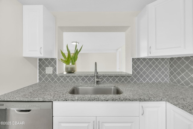 kitchen featuring dishwasher, a sink, white cabinetry, and decorative backsplash