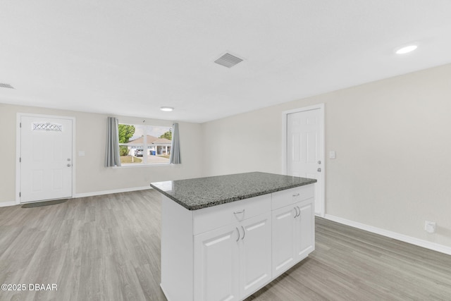 kitchen featuring light wood-style floors, a center island, and baseboards