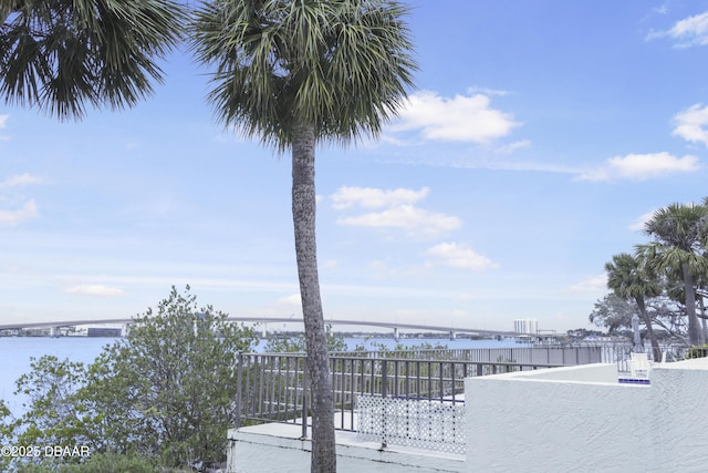 exterior space featuring a water view and fence