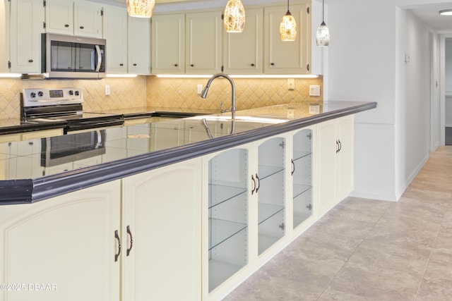 kitchen featuring baseboards, dark countertops, stainless steel appliances, pendant lighting, and backsplash