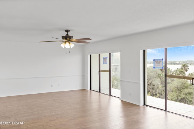 empty room featuring light wood-type flooring and a ceiling fan