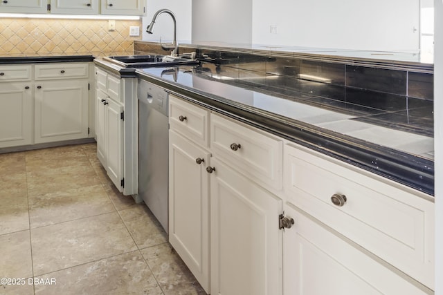 kitchen featuring dark countertops, white cabinetry, and a sink