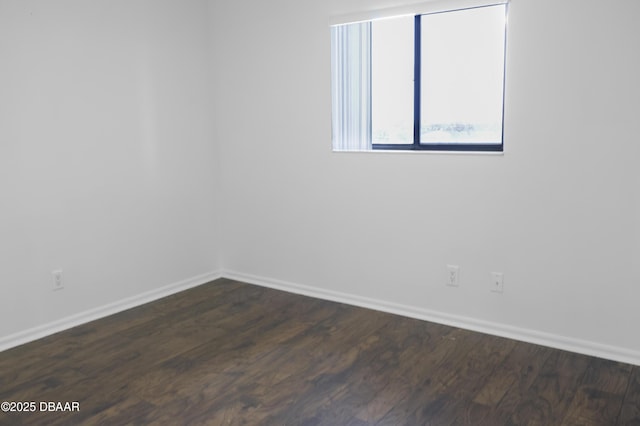 empty room with dark wood-style floors and baseboards