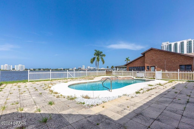 view of swimming pool featuring a water view and a patio